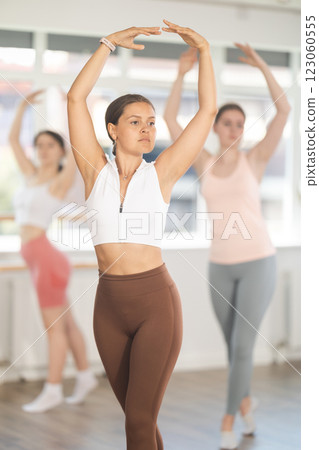 Young girl practicing basic ballet movements in beginners class 123060555