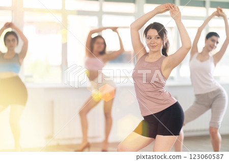 During lesson, girl learn to move and perform dance in heels with women companions 123060587