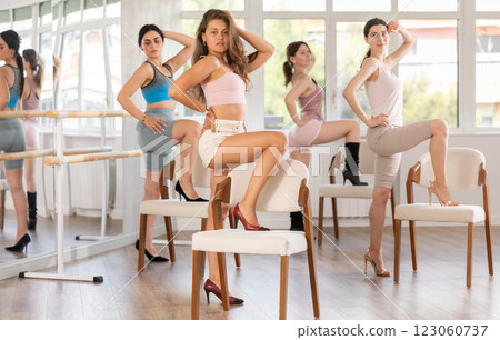 Stylish women learn to move beautifully and dance in heels with their companions during a lesson in studio 123060737