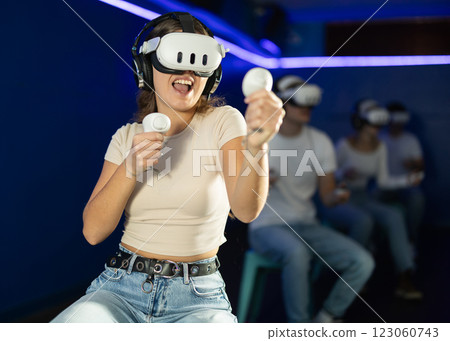 Girl in virtual reality glasses is playing a video game 123060743