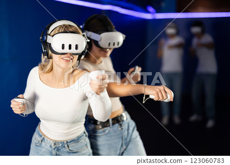 Two girls wearing virtual reality glasses participate in game with opponents 123060783