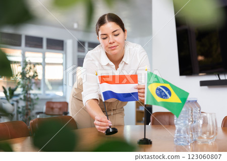 female assistant prepares conference room for diplomats of Brazil and Netherlands 123060807