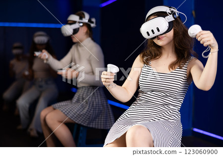 Young woman immersed in virtual reality game in gaming center Young woman immersed in virtual reality game in gaming center 123060900