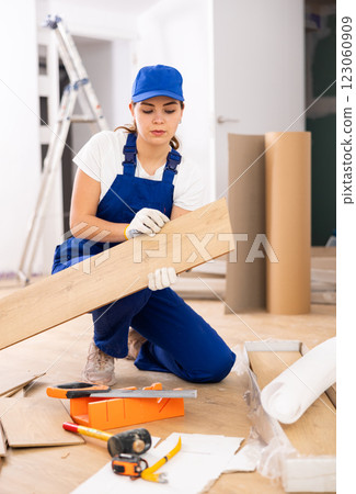 Female repairer installing laminate flooring 123060909