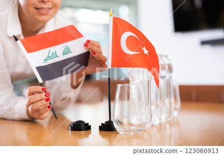 Little flag of Turkey on table and flag of Iraq put next to it by young woman Little flag of Turkey on table and flag of Iraq put next to it by young woman 123060913