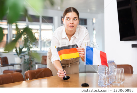 Young woman puts flags of Germany and France on table 123060993