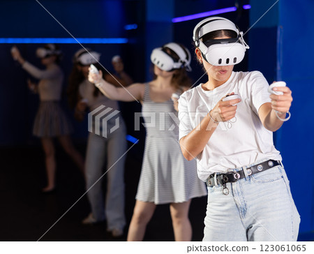 Young girls using virtual reality glasses - people having fun with new technology vr headset 123061065