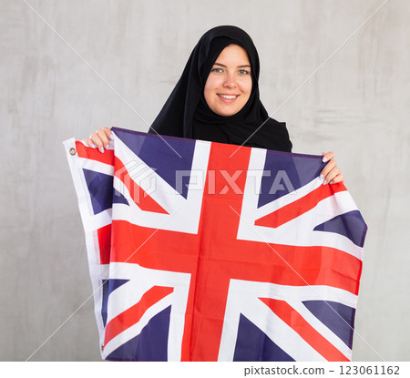 Happy young woman dressed in traditional islamic clothes with british flag Happy young woman dressed in traditional islamic clothes with british flag 123061162