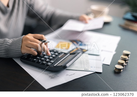 Finance bank tax expense accounting budget money businessman hand use calculator Financial calculate accountant close up calculator with graph chart write office desk Business expense analysis saving 123062370