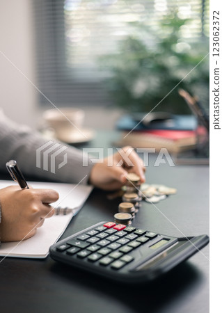 Finance bank tax expense accounting budget money businessman hand use calculator Financial calculate accountant close up calculator with graph chart write office desk Business expense analysis saving 123062372