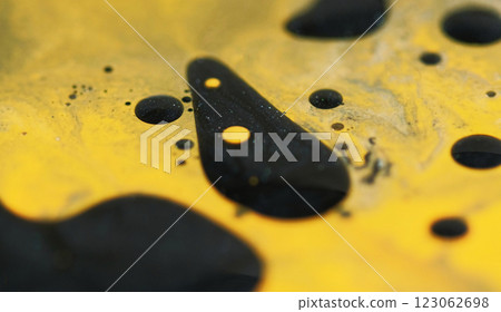 Blur spray blob. Fuel drop. Defocused yellow black color shiny glowing particles viscous oil spill drip texture paint ink water mix on abstract art background. 123062698