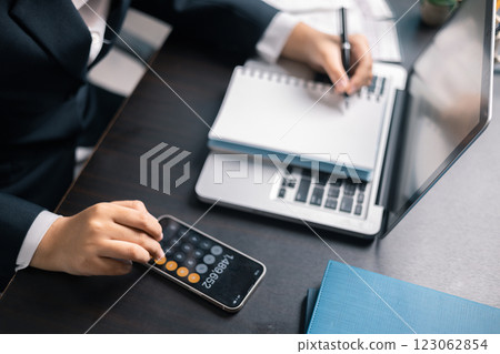 Finance bank tax expense accounting budget money businessman hand use calculator Financial calculate accountant close up calculator with graph chart write office desk Business expense analysis saving 123062854