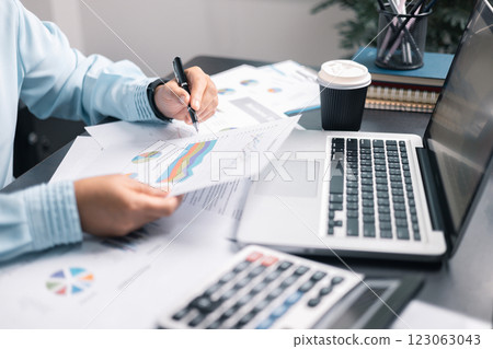 Finance bank tax expense accounting budget money businessman hand use calculator Financial calculate accountant close up calculator with graph chart write office desk Business expense analysis saving 123063043