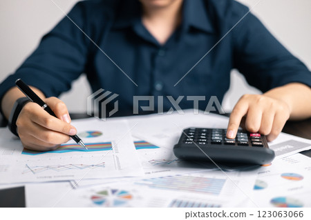 Finance bank tax expense accounting budget money businessman hand use calculator Financial calculate accountant close up calculator with graph chart write office desk Business expense analysis saving 123063066