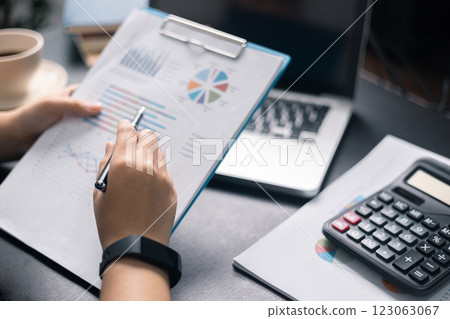 Finance bank tax expense accounting budget money businessman hand use calculator Financial calculate accountant close up calculator with graph chart write office desk Business expense analysis saving 123063067