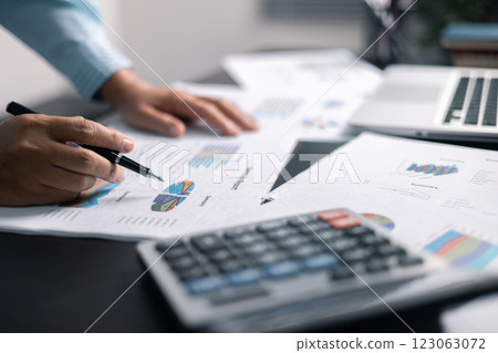 Finance bank tax expense accounting budget money businessman hand use calculator Financial calculate accountant close up calculator with graph chart write office desk Business expense analysis saving 123063072