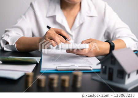 Finance bank tax expense accounting budget money businessman home for Business expense analysis saving use Financial calculate accountant close up calculator with graph chart hand write office desk 123063233