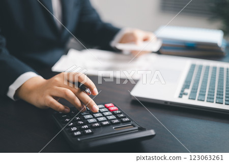 Finance bank tax expense accounting budget money businessman hand use calculator Financial calculate accountant close up calculator with graph chart write office desk Business expense analysis saving 123063261