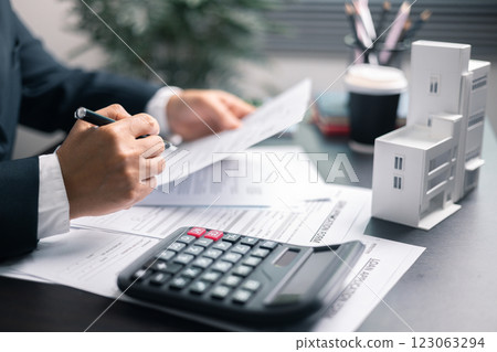 Finance bank tax expense accounting budget money businessman home for Business expense analysis saving use Financial calculate accountant close up calculator with graph chart hand write office desk 123063294