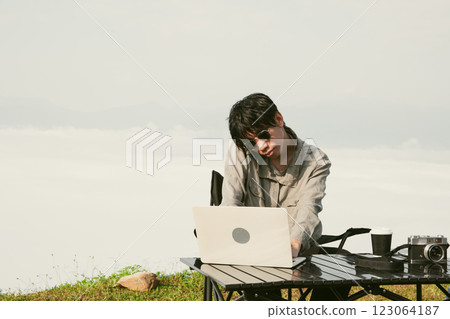 Young business man working computer on peak hill. Hiker online shopping on laptop at sunset, sunrise on top mountain, freelance person remote work with digital tablet. travel vacation holiday concept Young business man working computer on peak hill. Hiker online shopping on laptop at sunset, sunrise on top mountain, freelance person remote work with digital tablet. travel vacation holiday concept 123064187