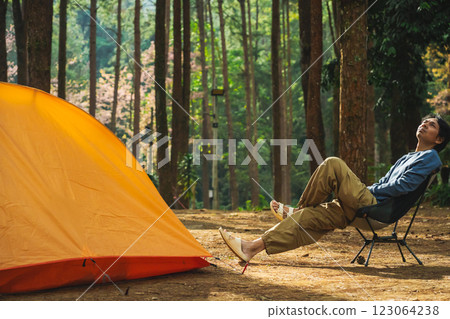solo traveler in nature concept with asian man camping and see pink cherry blossom tree and pine tree with sunrise in springtime season solo traveler in nature concept with asian man camping and see pink cherry blossom tree and pine tree with sunrise in springtime season 123064238