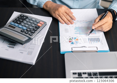 Finance bank tax expense accounting budget money businessman hand use calculator Financial calculate accountant close up calculator with graph chart write office desk Business expense analysis saving 123064306