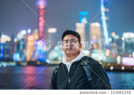 Man traveler visiting in Shanghai, China. Male Tourist with backpack sightseeing Shanghai view of Lujiazui in The Bund of Shanghai at night. landmark and popular for tourism attractions Man traveler visiting in Shanghai, China. Male Tourist with backpack sightseeing Shanghai view of Lujiazui in The Bund of Shanghai at night. landmark and popular for tourism attractions 123065258
