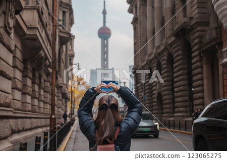 woman traveler visiting in Shanghai, China. Happy Female Tourist sightseeing Oriental Pearl Tower view in The Rock Bund of Shanghai. landmark and popular for tourism attractions. Travel and Vacation 123065275