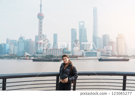 woman traveler visiting in Shanghai, China. Happy Female Tourist sightseeing Shanghai view of Lujiazui in The Bund of Shanghai. landmark and popular for tourism attractions. Vacation concept 123065277