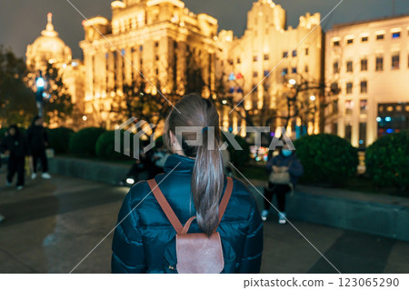 woman traveler visiting in Shanghai, China. Happy Female Tourist sightseeing Shanghai view in The Bund of Shanghai at night. landmark and popular for tourism attractions. Travel and Vacation concept 123065290
