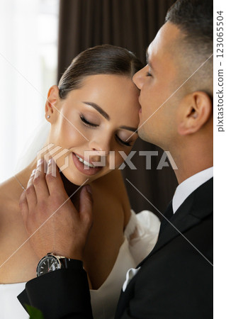 Groom caressing bride's neck during wedding day 123065504