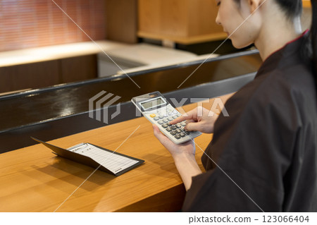 A restaurant employee calculating the bill 123066404