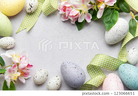 Easter eggs and spring flowers creating a frame on a gray background 123066651