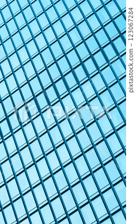 Abstract Grid Reflection. A close-up of a modern glass building facade, featuring a repetitive grid pattern with reflections of the sky Abstract Grid Reflection. A close-up of a modern glass building facade, featuring a repetitive grid pattern with reflections of the sky 123067284
