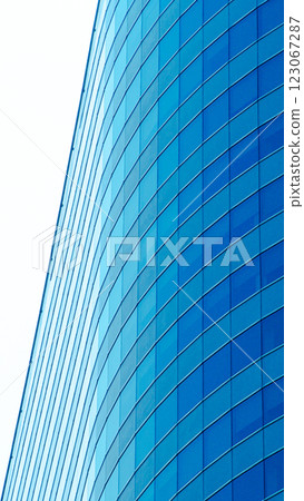 A modern high-rise with a sleek curved glass facade, ideal for business, real estate, and architectural presentations A modern high-rise with a sleek curved glass facade, ideal for business, real estate, and architectural presentations 123067287