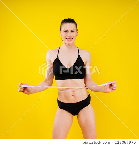 Weightloss, health and woman with measuring tape in a studio for her diet, exercise or wellness. Weightloss, health and woman with measuring tape in a studio for her diet, exercise or wellness. 123067979