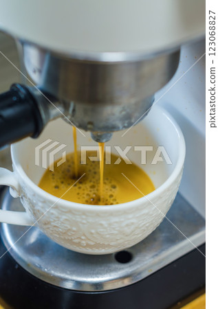 Fresh coffee pouring from coffee machine into a white textured cup. High quality photo Fresh coffee pouring from coffee machine into a white textured cup. High quality photo 123068827
