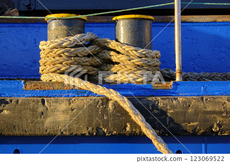 Nautical rope coiled on blue dock bollards 123069522