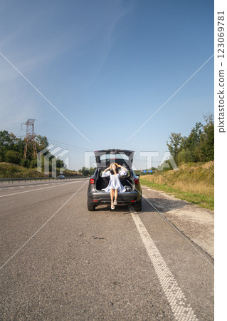 Woman Enjoying a Sunny Day by Her Car Woman Enjoying a Sunny Day by Her Car 123069781
