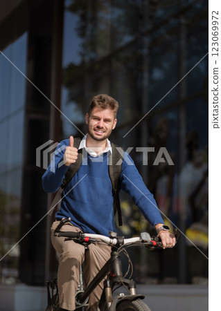 Portrait of a successful raising his arm in victory, celebrating success outside a modern office. 123069972