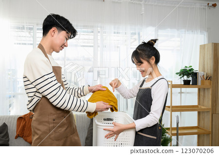 Happy asian couple enjoys tidying up their home on weekend Happy asian couple enjoys tidying up their home on weekend 123070206