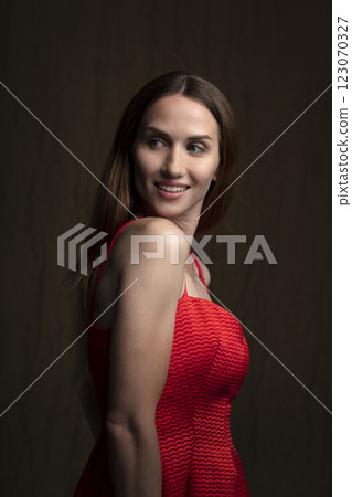portrait of a beautiful young woman in a red dress, studio shot on a dark background portrait of a beautiful young woman in a red dress, studio shot on a dark background 123070327