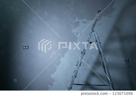Ladder stands beside wall as epoxy adhesive is applied to repair imperfections. Ladder stands beside wall as epoxy adhesive is applied to repair imperfections. 123071098