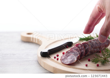 Matured salami on a cutting board with pink pepper and rosemary 123071443