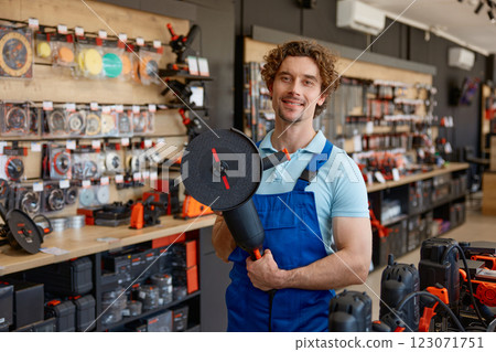 Worker testing big angle grinder at hardware store 123071751