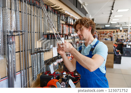 Man worker buying drill consumable tool to make holes in concrete at tools shop 123071752