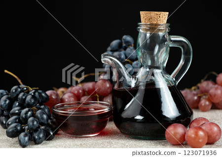 Red wine vinegar in glass vinegar bowls among grapes Red wine vinegar in glass vinegar bowls among grapes 123071936