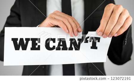 Businessman tearing up a sign saying - We Can't 123072191
