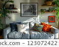 Interior fragment of a modern living room with a comfortable sofa, houseplants and shelves 123072422