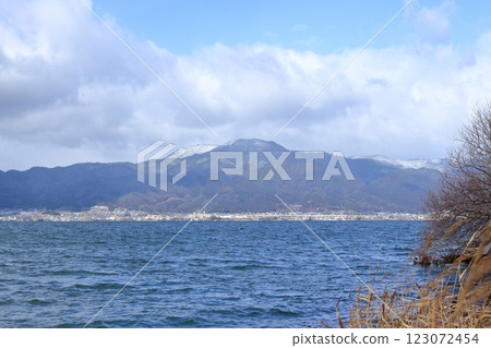 從琵琶湖對面的草津市湖畔望去，白雪皚皚的比叡山和山腳下的街道 123072454